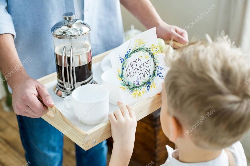 Father and son holding tray with card 