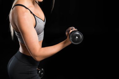 Dambıllarla egzersiz yapan kadın.