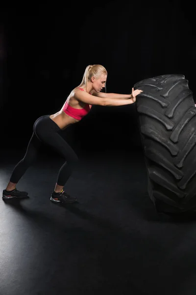 Mujer deportiva con neumático —  Fotos de Stock