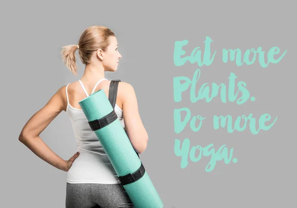 Sportlerin hält Yogamatte in der Hand lizenzfreie Stockbilder