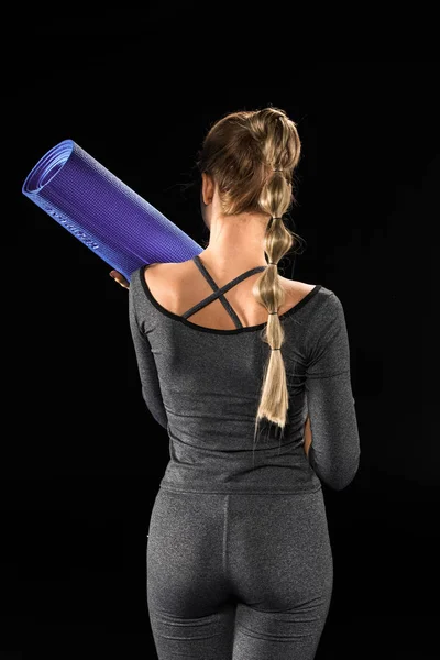 Sportswoman tenant tapis de yoga — Photo de stock