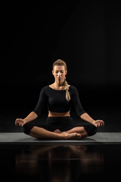 Jeune femme assise et méditant — Photo de stock