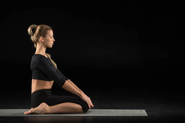 Женщина, сидящая в положении йоги — стоковое фото