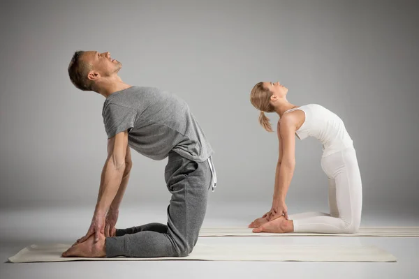 Pareja de pie en pose de yoga - foto de stock