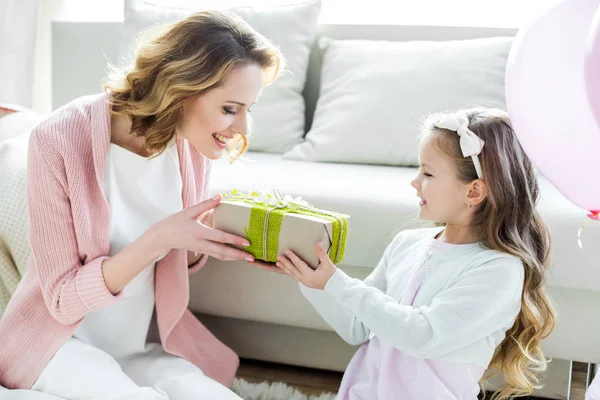 Chica presentando regalo a la madre - foto de stock