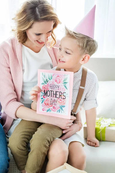 Madre e hijo con tarjeta de felicitación - foto de stock