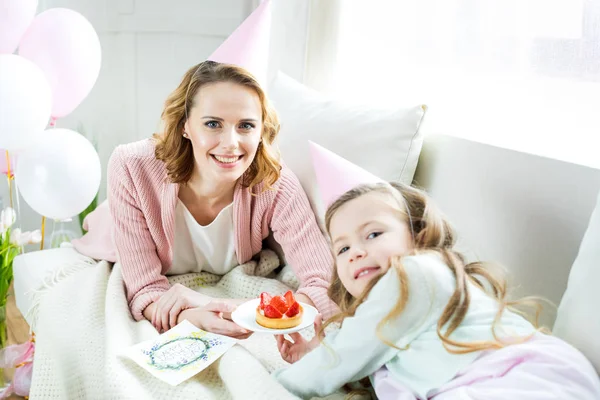 Madre e hija con pastel de fresa - foto de stock