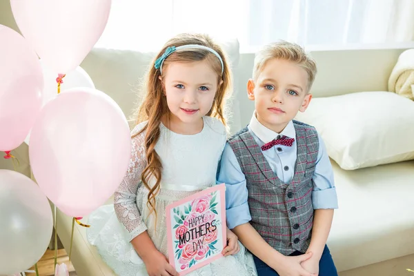 Hermanos con tarjeta del Día de las Madres - foto de stock