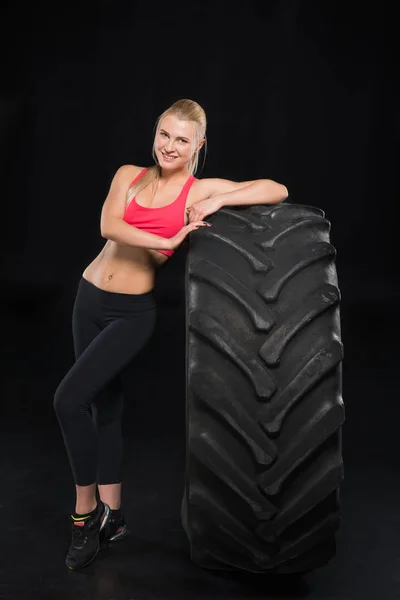Mujer deportiva con neumático - foto de stock