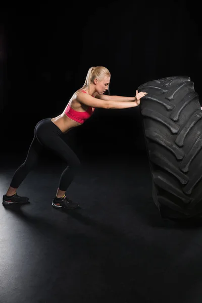 Mujer deportiva con neumático - foto de stock