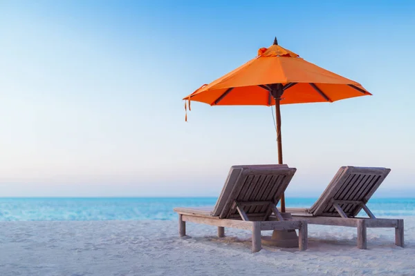 Splendida spiaggia alle Maldive. Rilassante cielo blu e sabbia bianca. Lettini in legno con ombrellone. Ispirazione lusso viaggio vacanza sfondo concetto . — Foto Stock