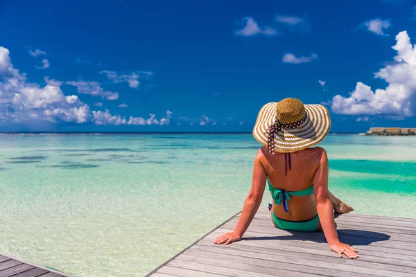 Jovem mulher magra deitada no cais, praia tropical, água azul e céu, ensolarado, pele bronzeada, biquíni, corpo sexy, banhos de sol, férias tropicais, relaxante. Verão fundo de viagem — Fotografia de Stock