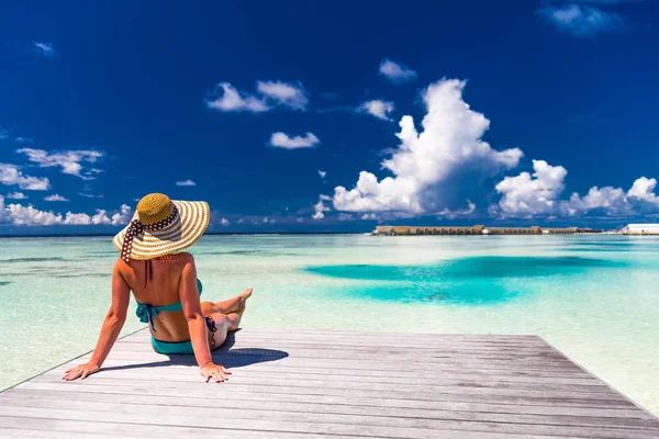 Jovem mulher magra deitada no cais, praia tropical, água azul e céu, ensolarado, pele bronzeada, biquíni, corpo sexy, banhos de sol, férias tropicais, relaxante. Verão fundo de viagem — Fotografia de Stock