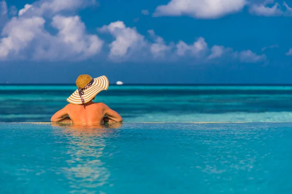 Jovem mulher magra deitada no cais, praia tropical, água azul e céu, ensolarado, pele bronzeada, biquíni, corpo sexy, banhos de sol, férias tropicais, relaxante. Verão fundo de viagem — Fotografia de Stock