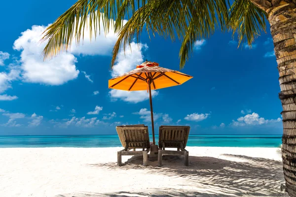 Prachtig strand achtergrond voor de zomer vakantie met zon, kokosnoot boom en strand houten bed op zand met prachtige blauwe zee en blauwe lucht. Zomer stemming zon strand achtergrond concept. — Stockfoto
