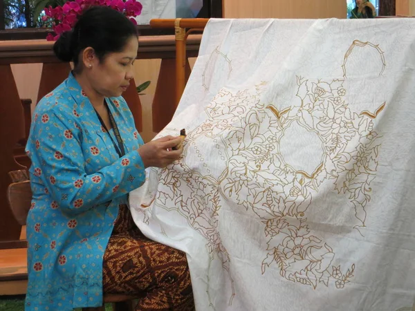 Jakarta, Endonezya - 8 Haziran 2017: uygulama bir kadın sıvı sıcak balmumu bir canting kullanarak aracı batik yapım süreci.
