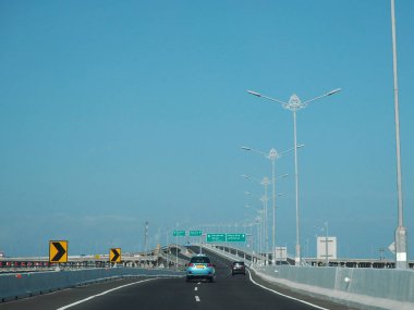 Denpasar, Endonezya - 23 Ağustos 2019: Benoa Körfezi boyunca uzanan 12.7 km uzunluğunda bir köprüyle Bali Mandara Toll Yolu 'ndan geçen araçlar.