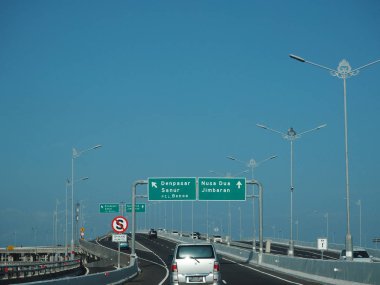 Denpasar, Endonezya - 23 Ağustos 2019: Benoa Körfezi boyunca uzanan 12.7 km uzunluğunda bir köprüyle Bali Mandara Toll Yolu 'ndan geçen araçlar.