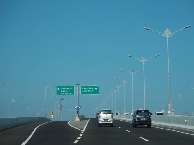 Denpasar, Endonezya - 23 Ağustos 2019: Benoa Körfezi boyunca uzanan 12.7 km uzunluğunda bir köprüyle Bali Mandara Toll Yolu 'ndan geçen araçlar.
