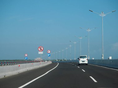 Denpasar, Endonezya - 23 Ağustos 2019: Benoa Körfezi boyunca uzanan 12.7 km uzunluğunda bir köprüyle Bali Mandara Toll Yolu 'ndan geçen araçlar.