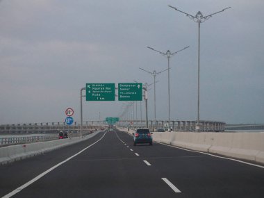 Denpasar, Endonezya - 23 Ağustos 2019: Benoa Körfezi boyunca uzanan 12.7 km uzunluğunda bir köprüyle Bali Mandara Toll Yolu 'ndan geçen araçlar.