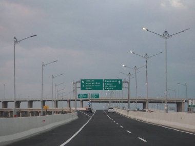 Denpasar, Endonezya - 23 Ağustos 2019: Benoa Körfezi boyunca uzanan 12.7 km uzunluğunda bir köprüyle Bali Mandara Toll Yolu 'ndan geçen araçlar.