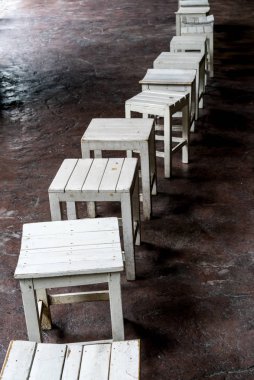 Beton zemin üzerinde beyaz ahşap tabureler