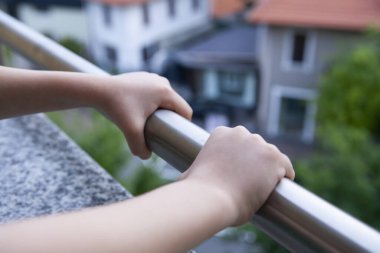 Coronavirus pandemisi sırasında hapishane evinin balkonunda bir çocuğun elleri