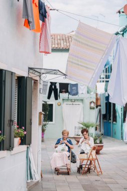 Women embroidering on street clipart