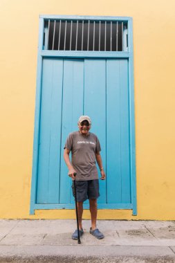 Havana, Küba - 5 Ocak 2017: Yerel adam mavi ve sarı duvarın önünde ayakta gülümseyen