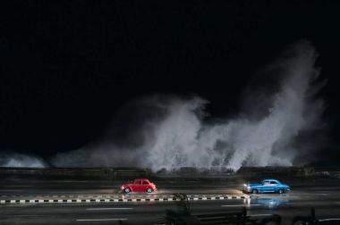 Havana, Küba'da su dolu yolda araba sürmek