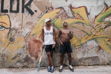 Havana, Küba - 22 Ocak 2017: beysbol sopası ve eldiven ile graffiti duvar önünde duran iki genç