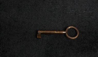 Karanlık yüzeyinde izole eski demir anahtar