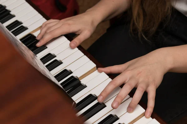 Mani di una ragazza che suona il pianoforte primo piano — Foto Stock