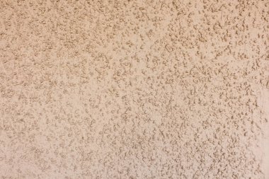 Küçük taşlar rastgele yüzeye dağılmış, ince bir sarı-kahverengi-turuncu kil tabakasıyla kaplanmış.