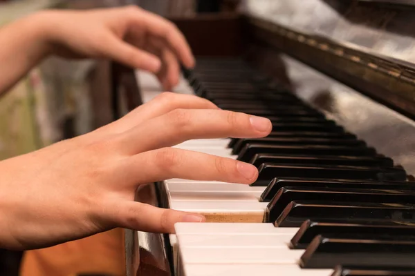 Manos de una chica tocando el piano de cerca Imagen de archivo