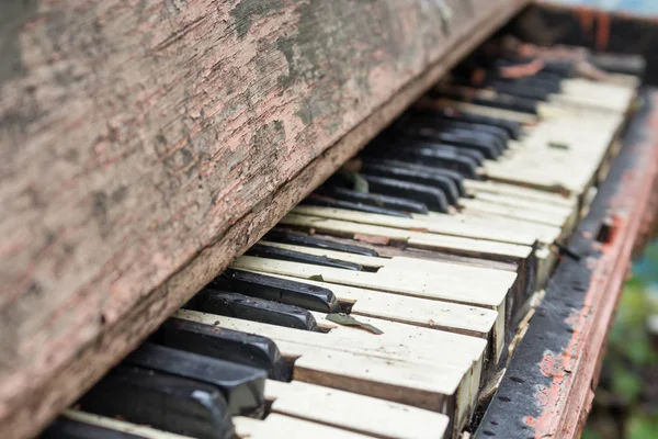 Old broken piano close-up, drops and leaves on broken keys