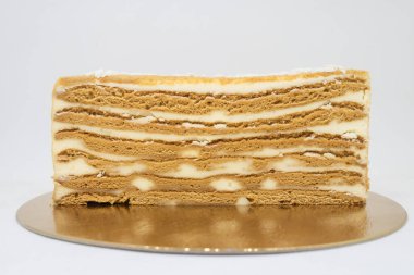 Beyaz arkaplanlı yarım bir pasta. Pastayı görünür katmanlar ve beyaz dolgulu kes (krema).