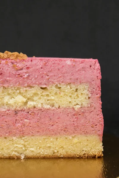 Een halve taart met een zwarte achtergrond. Snijd taart met zichtbare lagen en roze vulling — Stockfoto