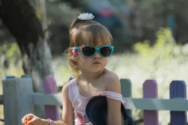 Güneş gözlüğü mesafe içine bakarak onun çıplak omuz ile küçük bir fashionista