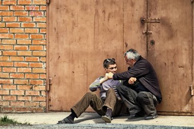 Vinnitsa, Ukraine - May 9, 2018: Drunkards with a feverish glint in their eyes. Drunkards knocking on their fists clipart