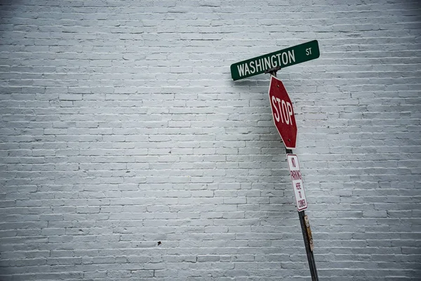 Straßenschild vor einer weißen Wand — Stockfoto