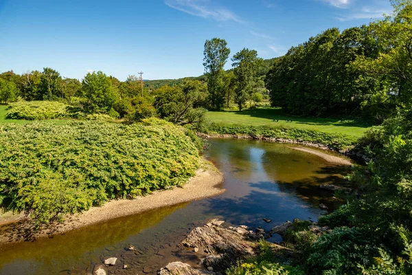 En farverig landcape afspejles i Little River i Stowe, Vermont - Stock-foto