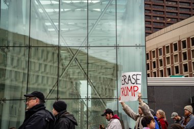 Boston Yaşam Yürüyüşü siyasi mitinginde barış için yürüyüş yapan protestocu gururlu gökkuşağı bayrağı.