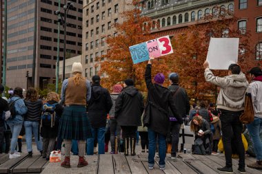 Boston Yaşam Yürüyüşü siyasi mitinginde barış için yürüyüş yapan protestocu gururlu gökkuşağı bayrağı.