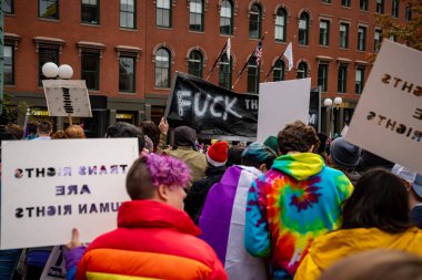 Boston Yaşam Yürüyüşü siyasi mitinginde barış için yürüyüş yapan protestocu gururlu gökkuşağı bayrağı.