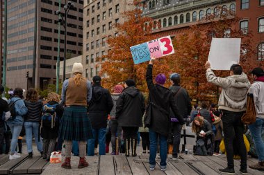 Boston Yaşam Yürüyüşü siyasi mitinginde barış için yürüyüş yapan protestocu gururlu gökkuşağı bayrağı.