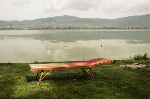 Isolato Lettino sulla piccola spiaggia vicino a un lago — Foto Stock