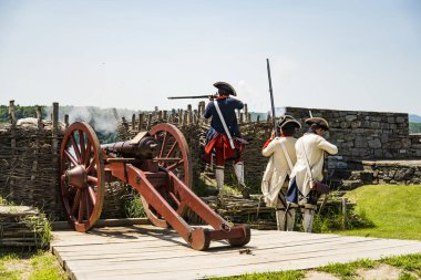 FORT TICONDEROGA, NEW YORK STATE - JUNE 23, 2019: Young men dressed as soldiers, demonstrating how guns were used in fighting the wars that shaped America.