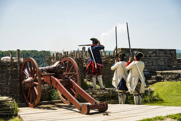 ФОРТ-ТИКОНДЕРОГА, НЬЮ-ЙОРК - 23 июня 2019 года: Молодые люди, одетые как солдаты, демонстрируют, как использовалось оружие для ведения войн, которые сформировали Америку
.